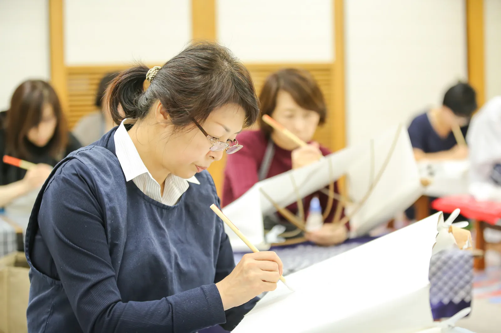 着付けが終わって鏡で着姿を見る青山きもの学院の先生と生徒